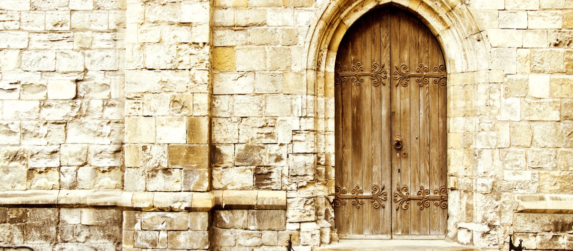 Old gothic door in the brick wall. Architecture.
